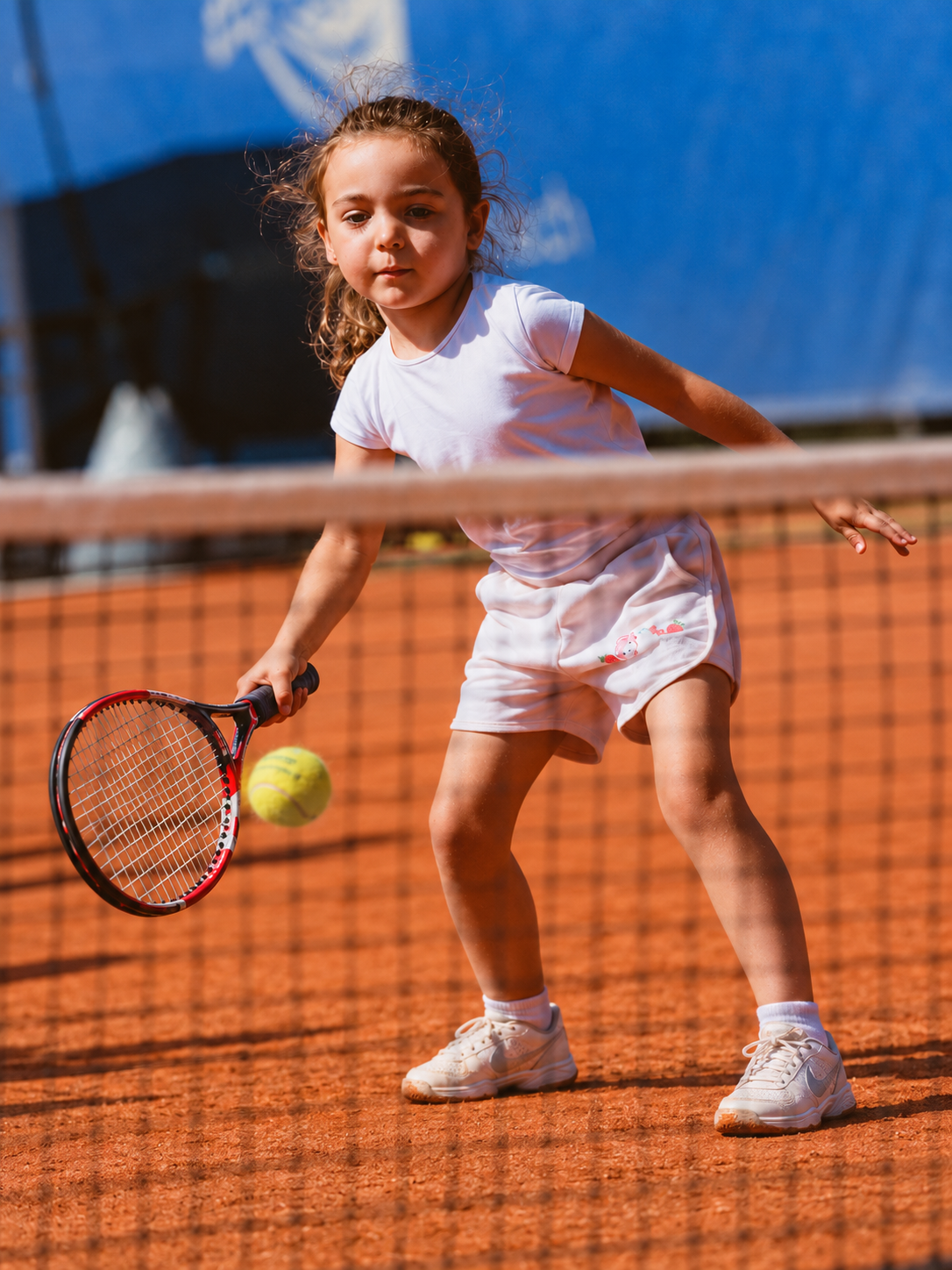 Une jeune joueuse de tennis sur un court en terre battue